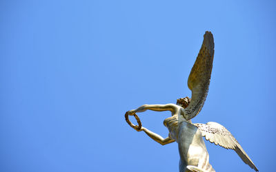 Low angle view of statue against clear blue sky