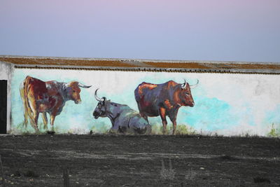 Cows standing in field against sky