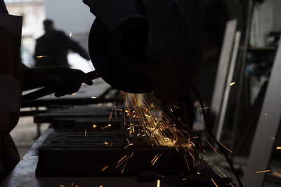 Cropped hand of man welding metal