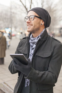 Young man using mobile phone in city