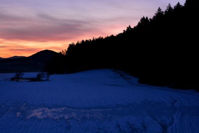 Scenic view of snowcapped mountains against sky during sunset