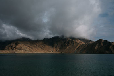 Scenic view of sea and mountains against sky