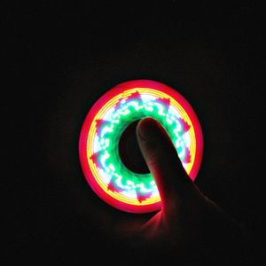 Close-up of hand holding illuminated light against black background