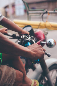 Cropped image of father and son riding motorcycle on road