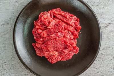 Directly above shot of red meat in bowl