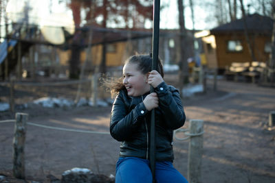 A girl rides a children's bungee in the park