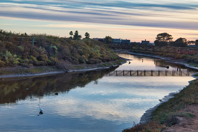 Scenic view of river against sky during sunset