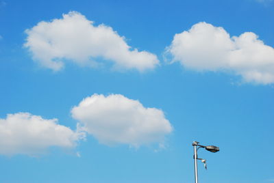 Low angle view of street light against blue sky