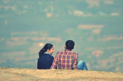 Rear view of couple on land against sky