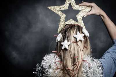 Rear view of blond woman with star shape christmas decorations