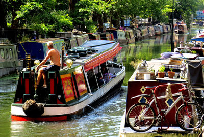 People on boats moored in water