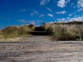 Road by landscape against blue sky