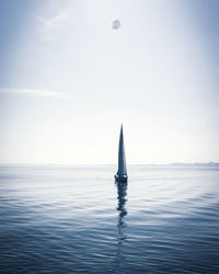 Sailboat in sea against sky