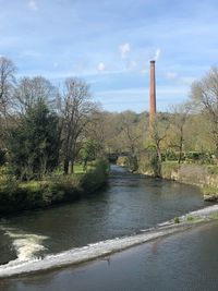 River by factory against sky