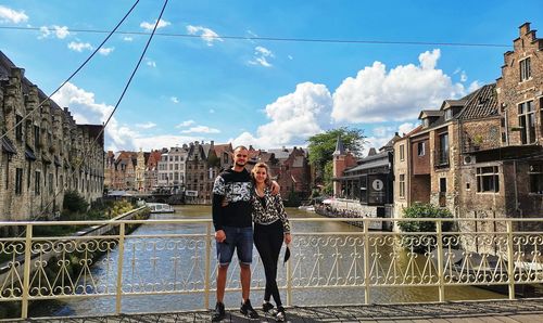 Full length of man standing on canal against buildings in city
