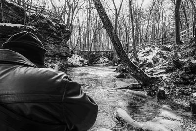 Rear view of man in snow covered forest