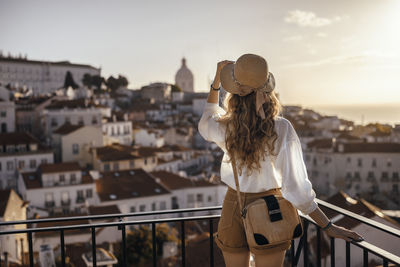 Man looking at city buildings against sky