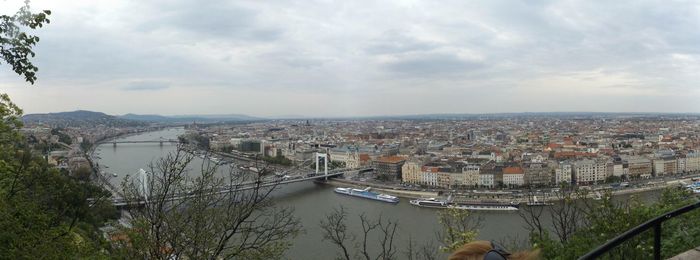 View of cityscape against cloudy sky