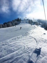 Ski slope at the mountain unterberghorn in koessen, tyrol austria in the sunlight with some skiers