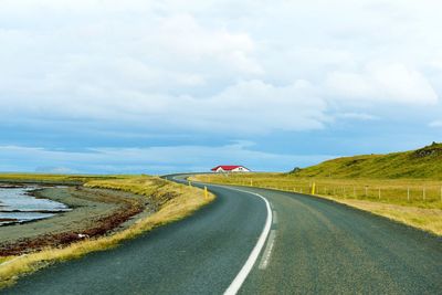 Empty road against cloudy sky