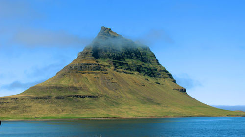 Scenic view of sea and mountains against sky