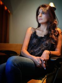 Beautiful young woman sitting at home