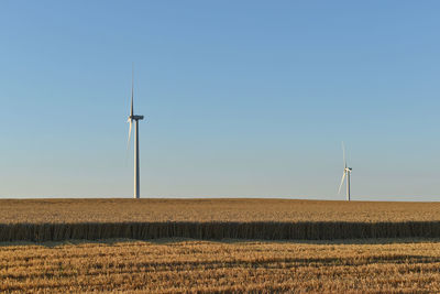 Windmill on field against clear sky