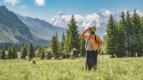 Rear view of woman standing on field