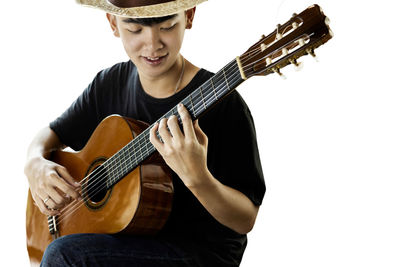 Low section of man playing guitar against white background