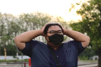 Portrait of young man standing against blurred background