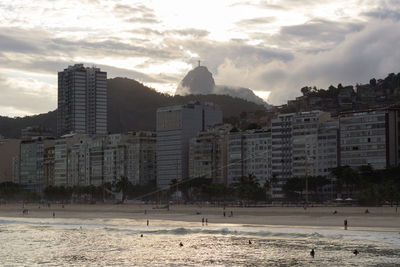 View of buildings at beach against cloudy sky