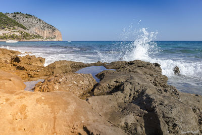 Scenic view of beach against clear blue sky