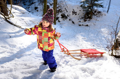 Cute girl standing on snow during winter