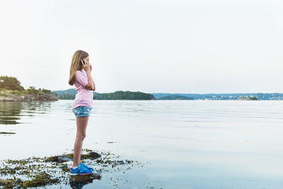 Girl with cell phone at water