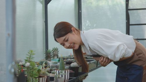 Young woman looking at potted plants