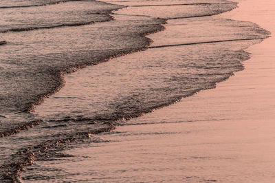 Waves reaching shore during sunset