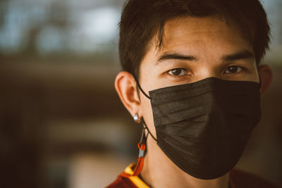 Young man wearing a black mask to protect against the virus.