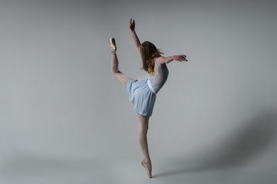 Ballet dancing against gray background