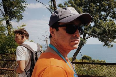 Portrait of young man wearing sunglasses against plants