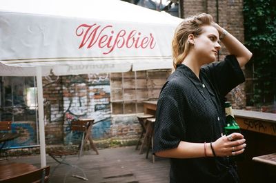 Young woman standing on table at restaurant