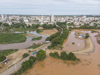 River flooding due to rain causes large mud next to a dam that prevents the rivers from meeting 