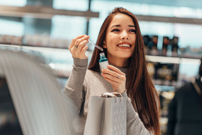 Portrait of smiling young woman holding umbrella