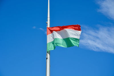 Low angle view of flag against blue sky