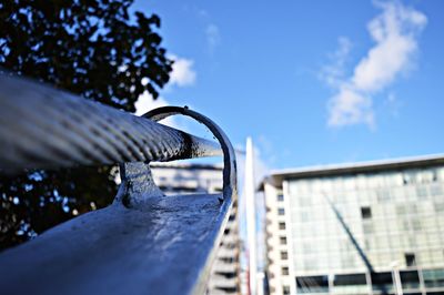 Low angle view of railing against blue sky
