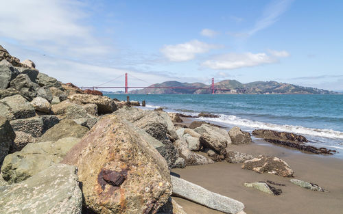 Panoramic shot of rocks on sea shore against sky