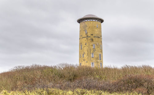 Low angle view of lighthouse on field against sky