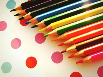 High angle view of colorful pencils on spotted table