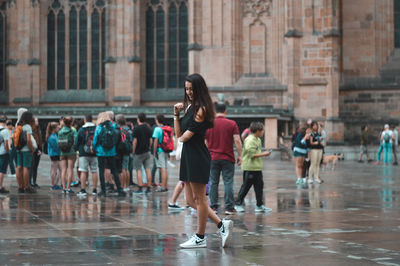 Young woman walking on wet street
