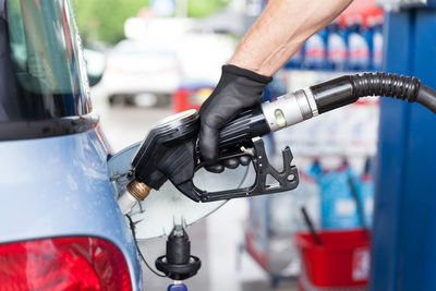 Cropped image of hand refueling car