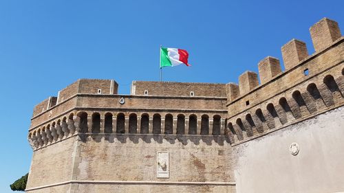 Low angle view of historical building against clear blue sky